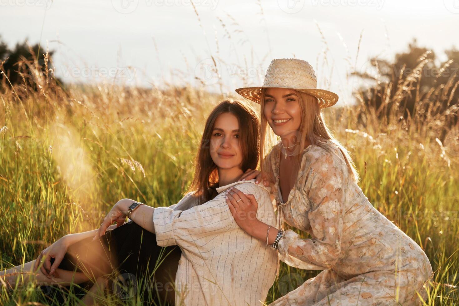 Sitting ,together. .Two women friends are in the rural field photo