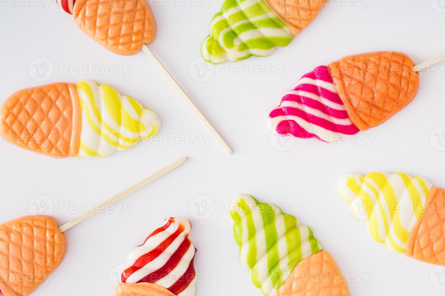 Vibrant and playful summer pattern made of ice cream shaped lollipops on white background. Creative candy concept. Colorful sweet food background. photo