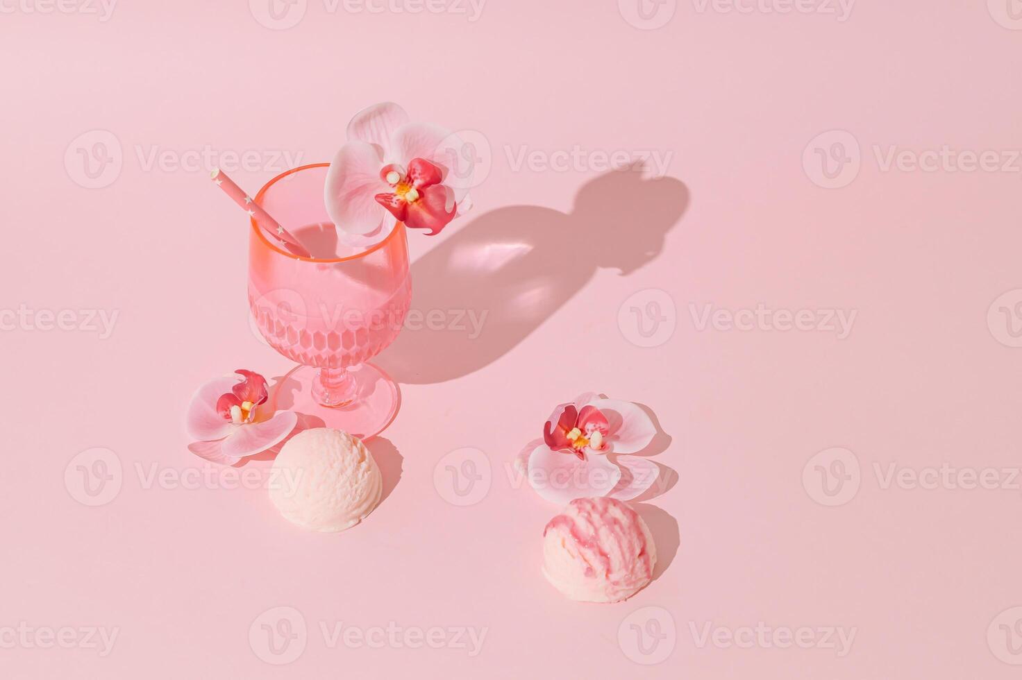 Summer scene with pink tropical drink, orchid flowers and ice cream scoops on pastel pink background. Sun and shadows. Minimal cocktail concept. Trendy summertime party idea. Summer aesthetic. photo