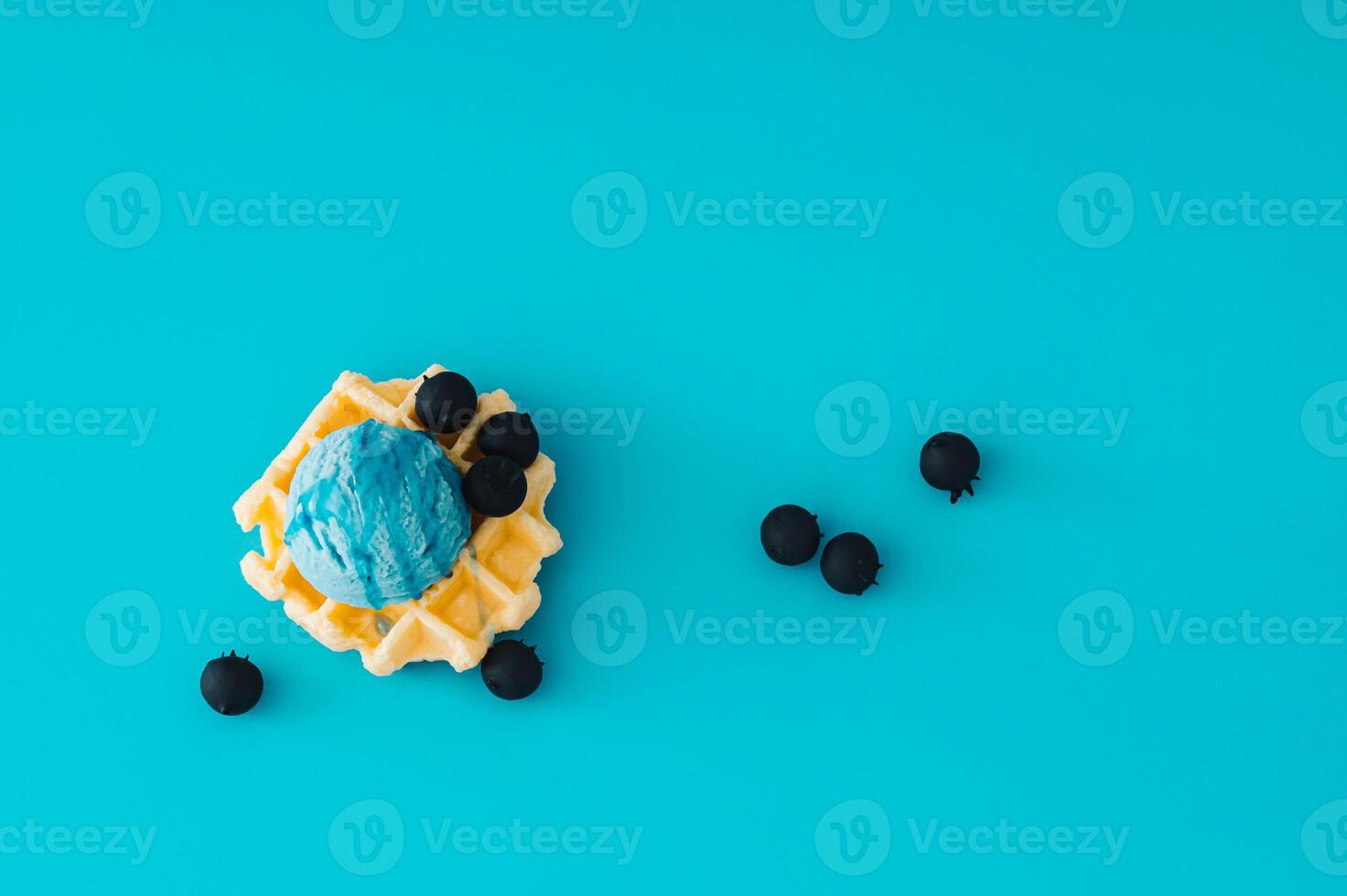 Waffle and blue ice cream with topping and fresh blueberries on light blue background. Minimal sweet food concept. Trendy delicious dessert idea. Flat lay style. photo
