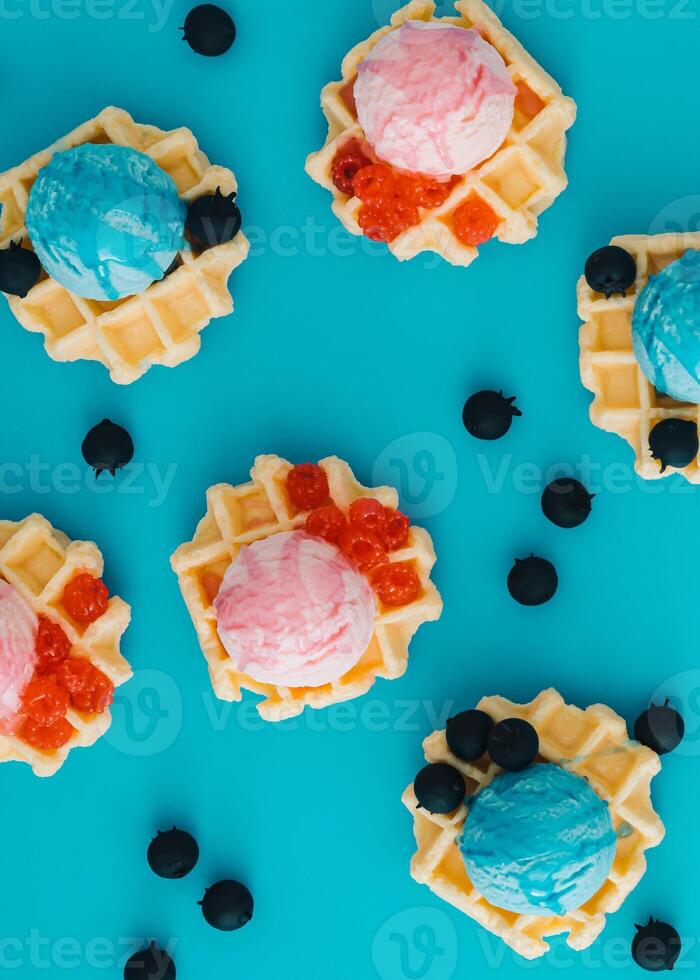 Pattern with waffles, ice cream scoops, raspberries and fresh blueberries on pastel blue background. Sweet food concept. Perfect for summer themed designs and playful backdrops. Flat lay. photo