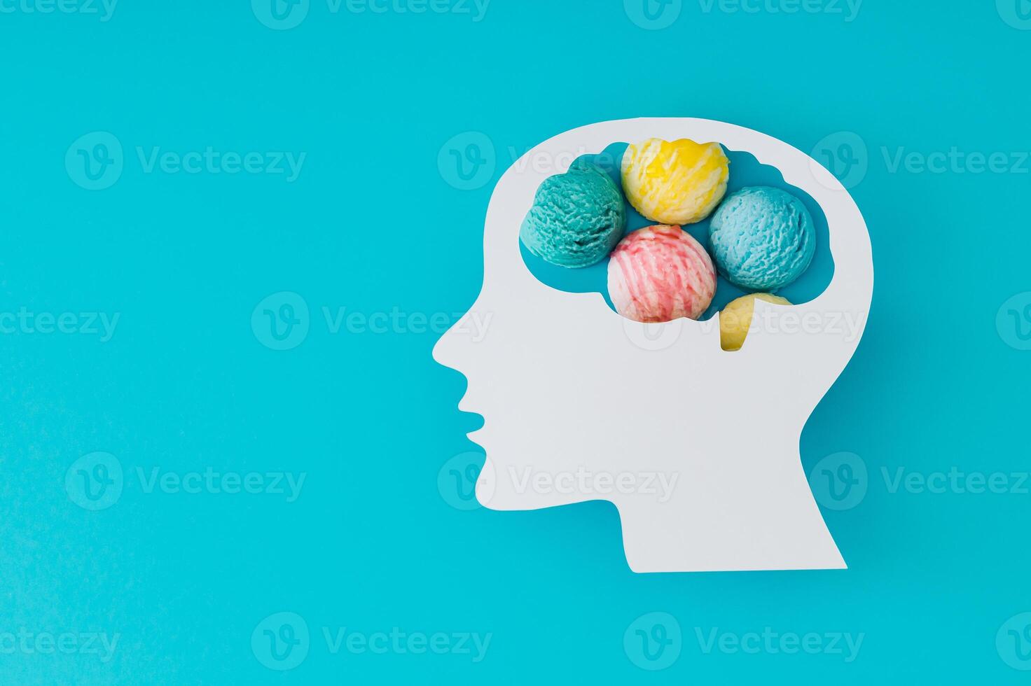 Profile of paper human head with brain containing ice cream on blue background. Conceptual image symbolizing cravings, sweet summer thoughts, or playful mind. Creative background design. Flat lay. photo