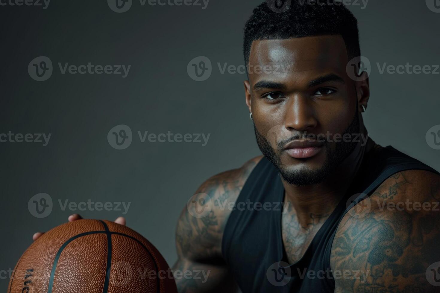 Athletic black man with tattoos holding a basketball, showcasing skill and confidence in a training session photo