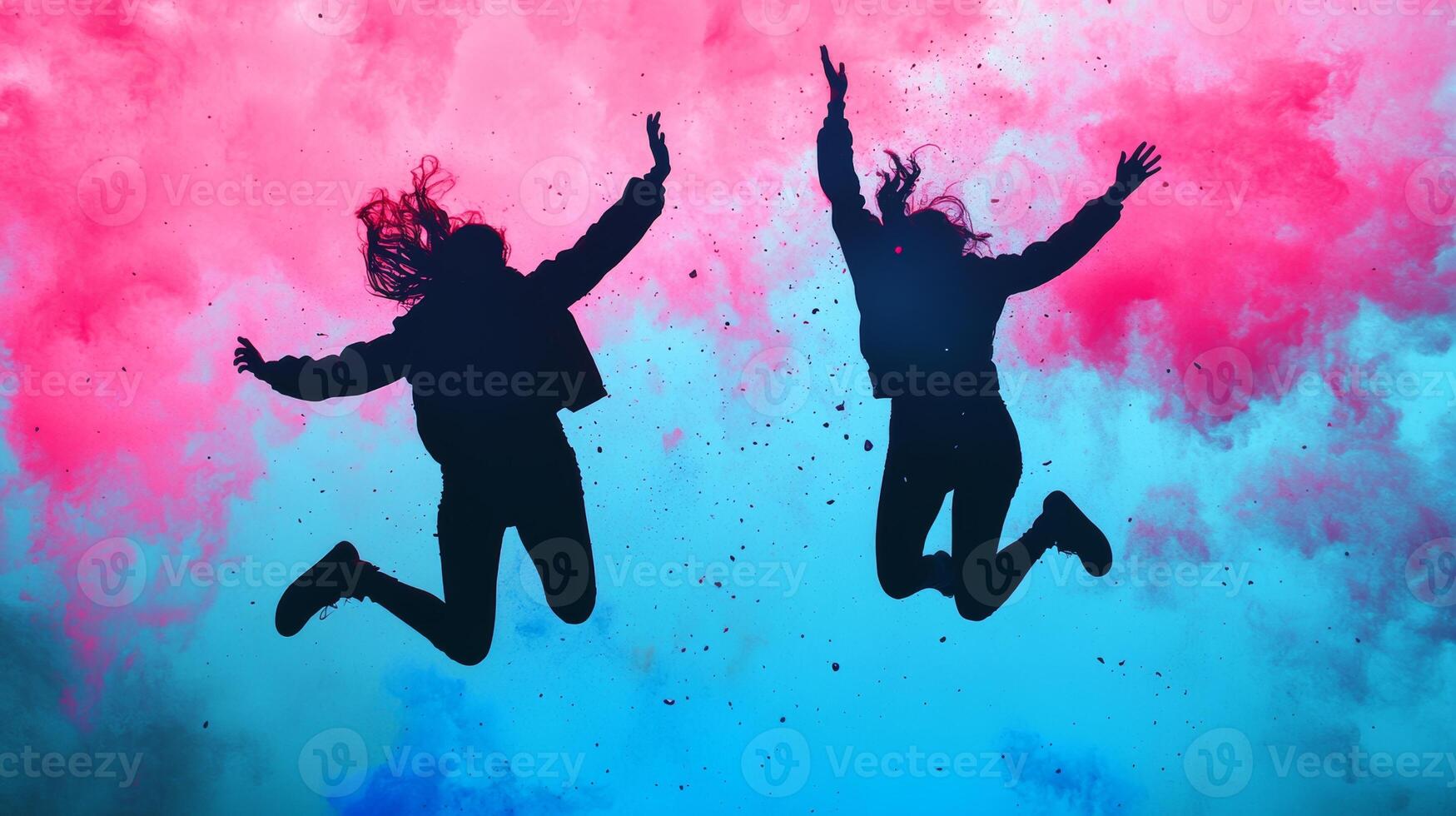 Two silhouettes leap joyfully in a vibrant splash of pink and blue during a dynamic outdoor celebration at sunset photo