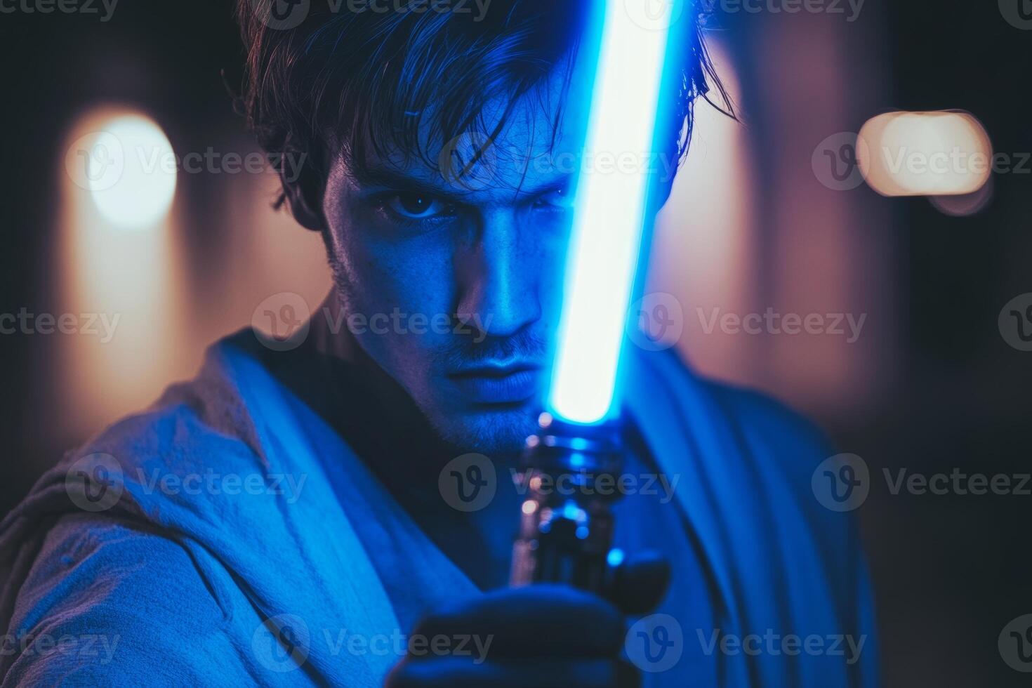 A man confidently wielding a blue lightsaber, showcasing strength and creativity during an evening adventure photo