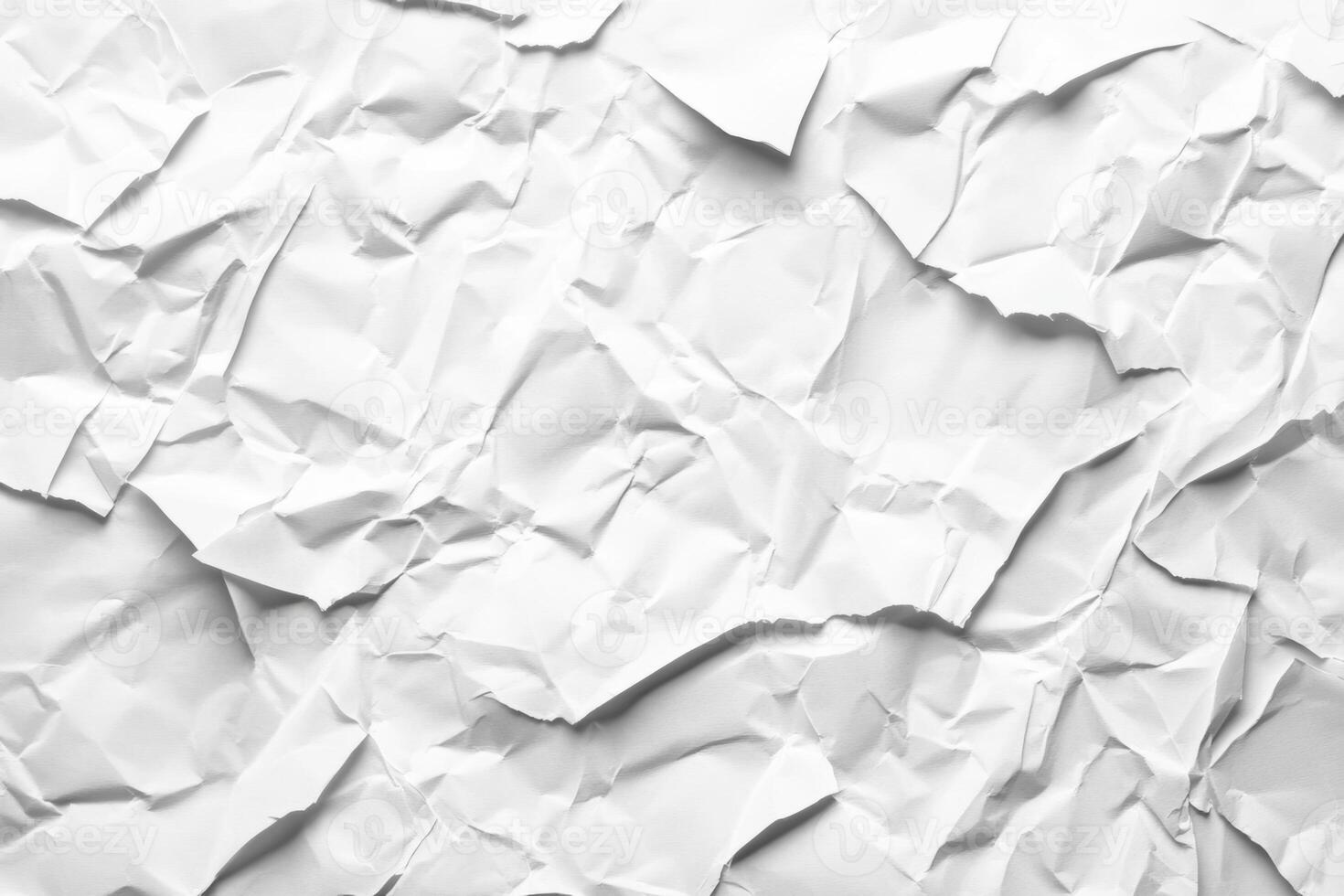 Torn piece of white paper with crumpled texture scattered on a surface in a simple indoor setting photo