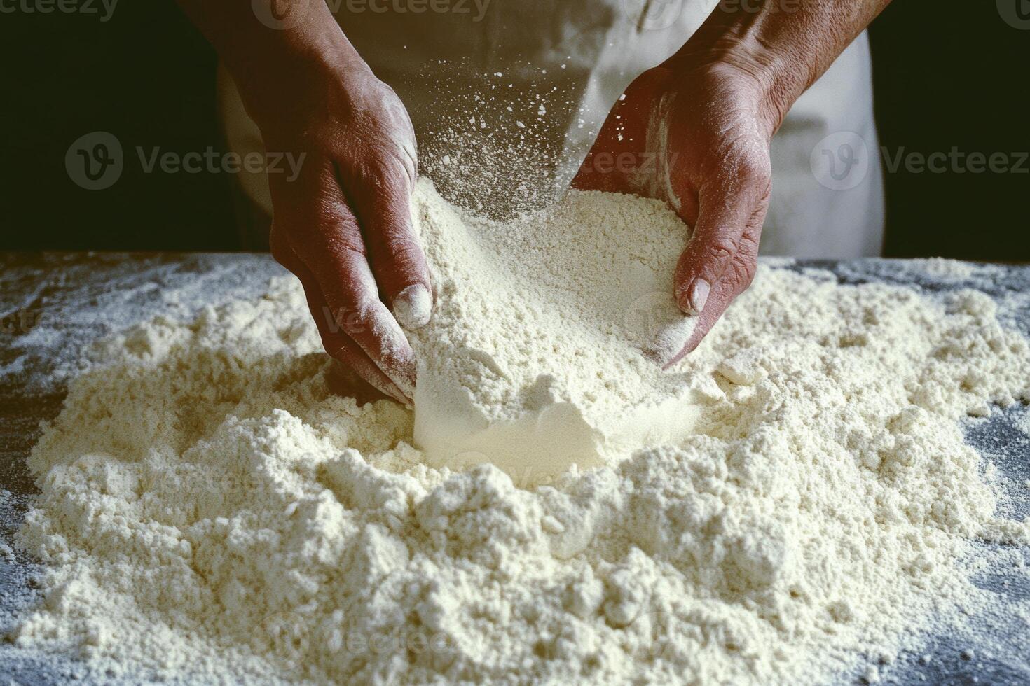 Anonymous woman preparing flour for kneading with hands, creating a pile on a dark surface in a cozy kitchen during daylight photo