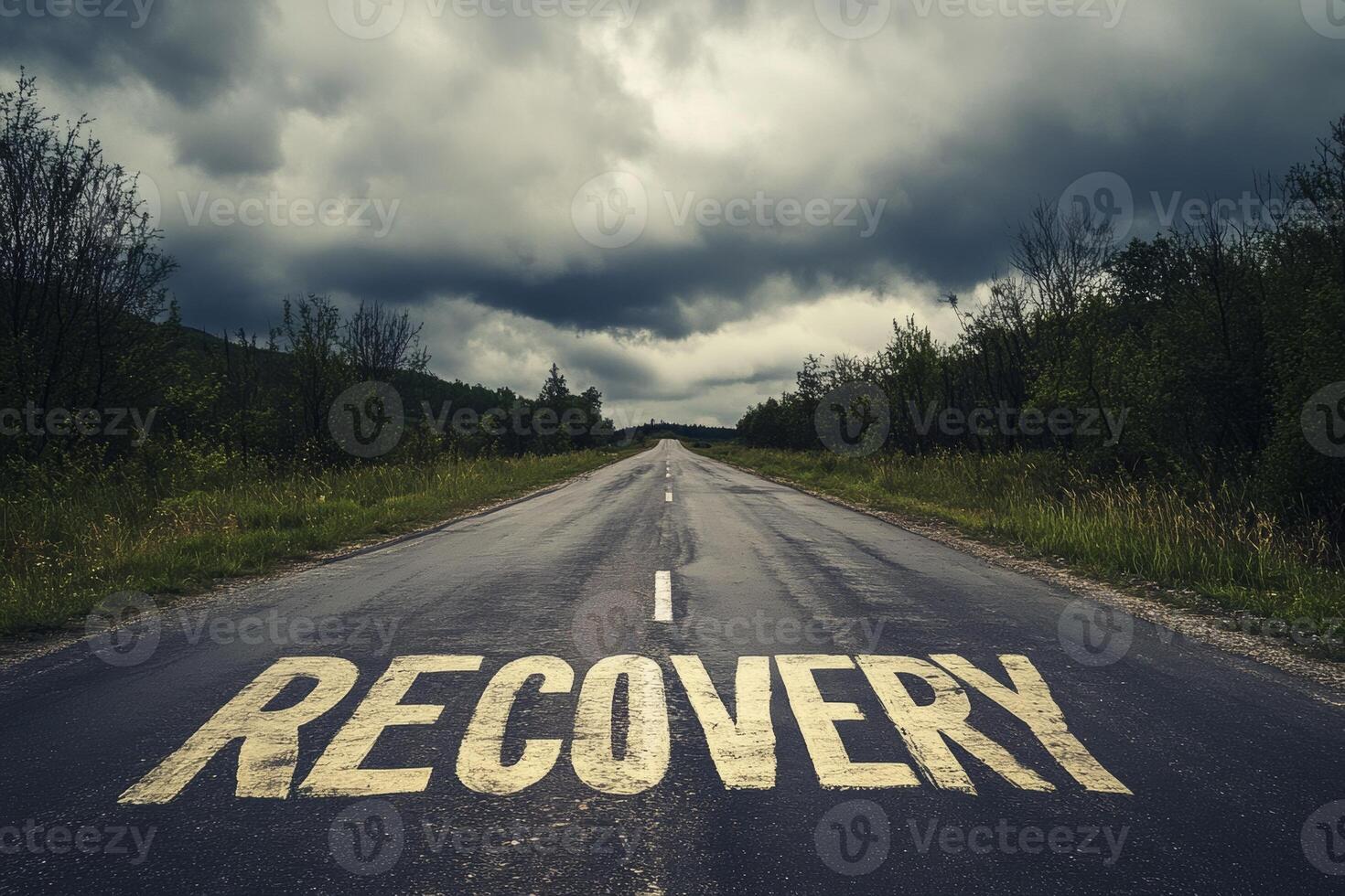 An empty road stretches into the distance, featuring the word 'RECOVERY' painted on the pavement beneath an overcast sky photo
