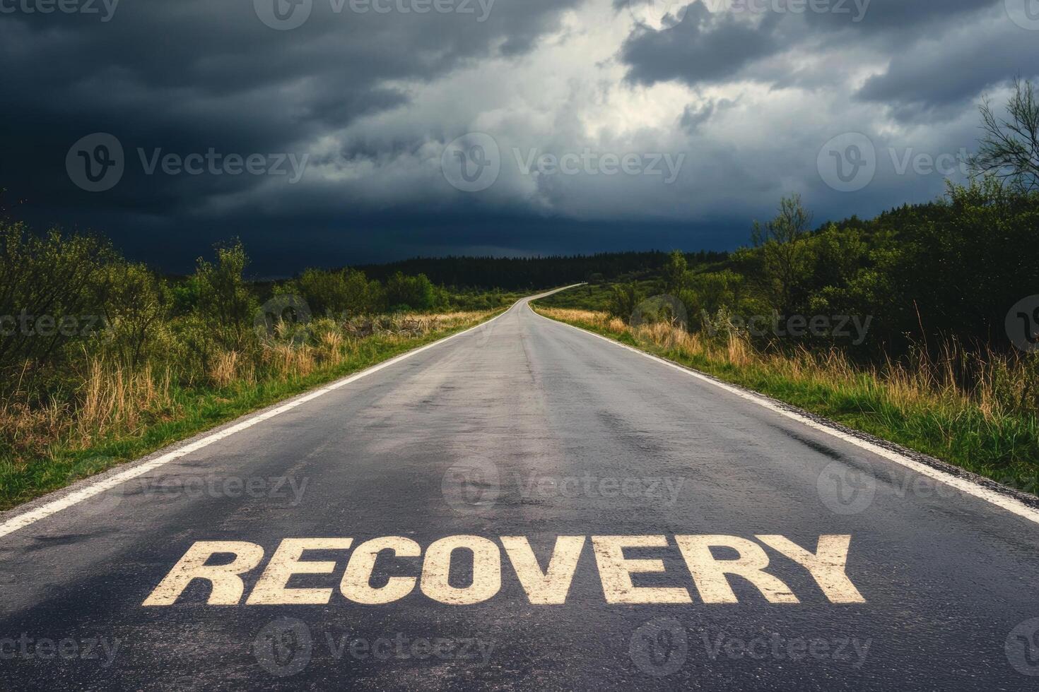 An empty road marked with the word recovery stretches into the horizon under an overcast sky photo