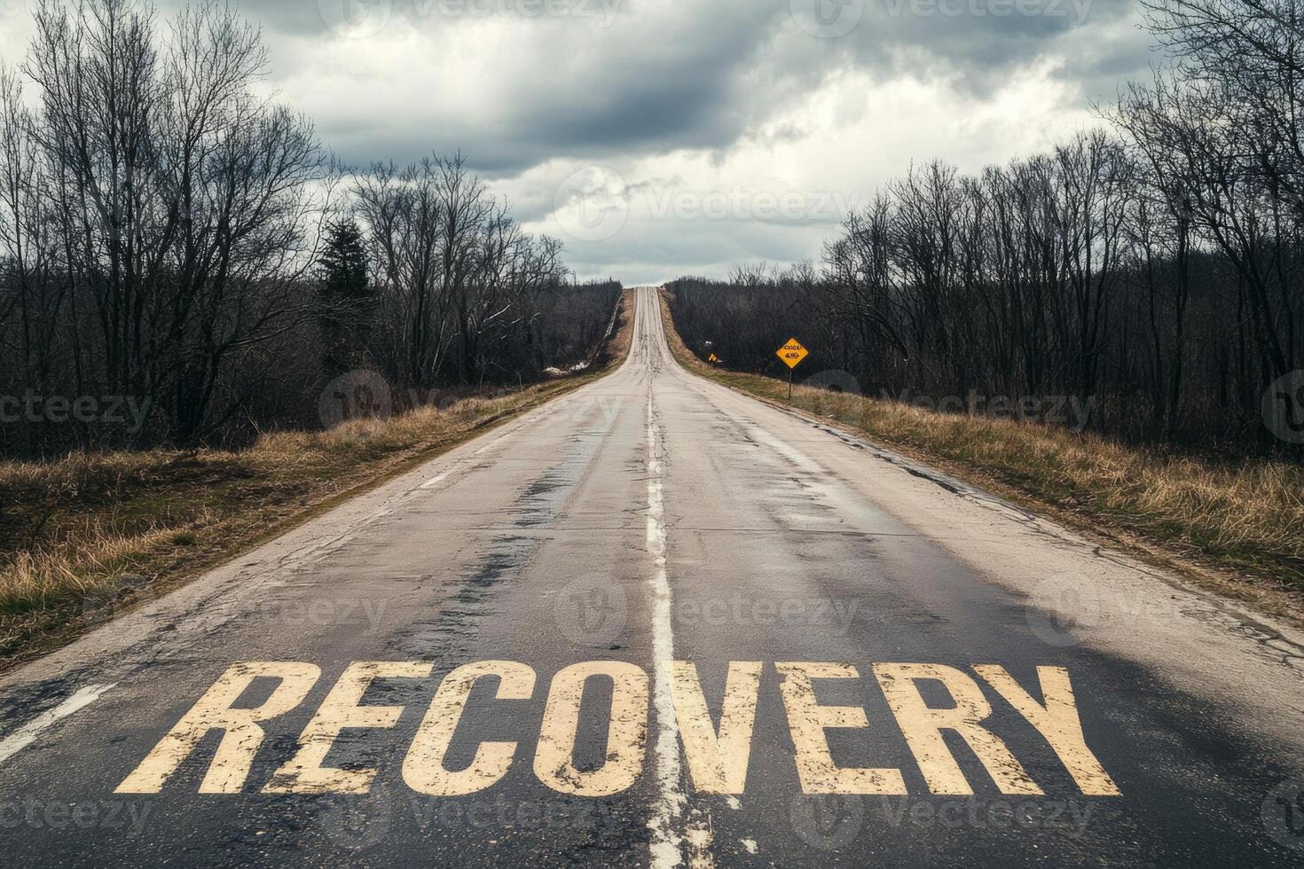Empty road with 'Recovery' painted on the pavement, stretching into the horizon under an overcast sky, conveying a hopeful message photo