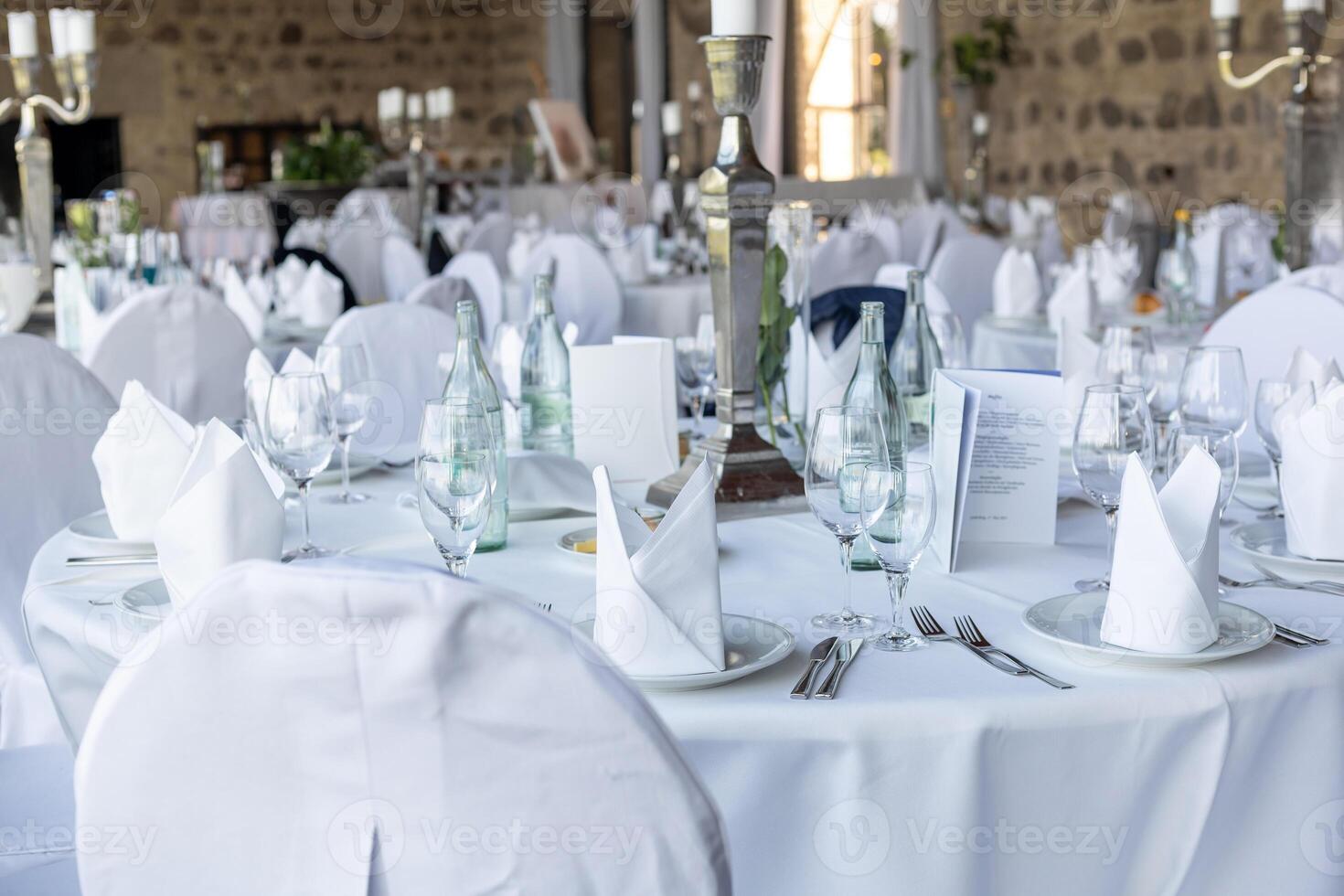 Elegant dining setup in a luxurious venue for a special event surrounded by stone walls and beautiful decor photo