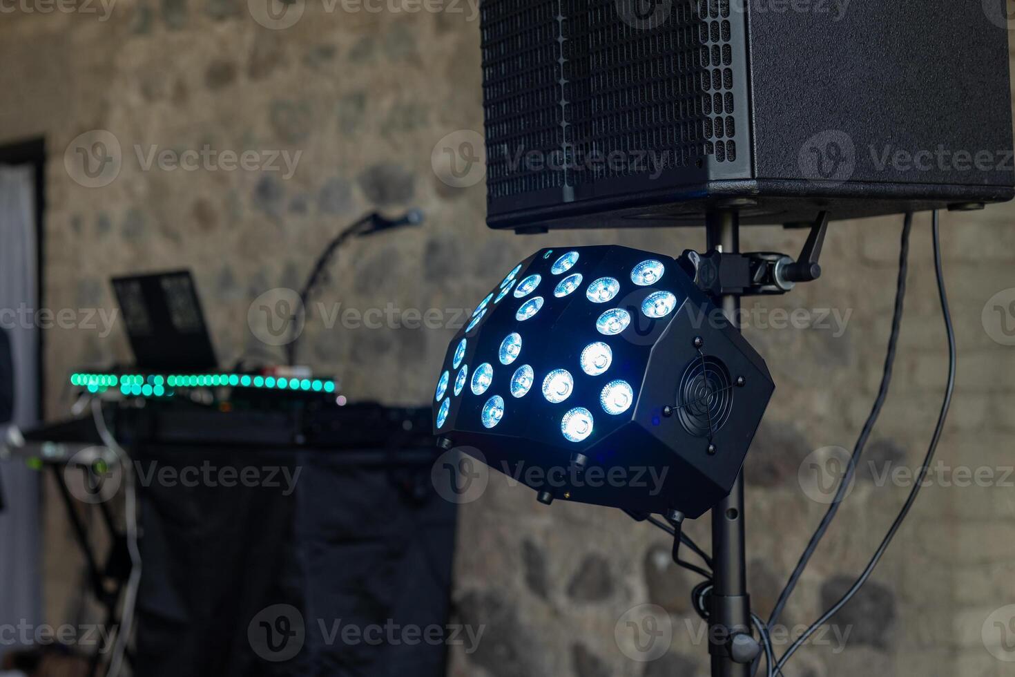 Lighting and sound equipment set up for an evening event in a rustic venue with stone walls photo