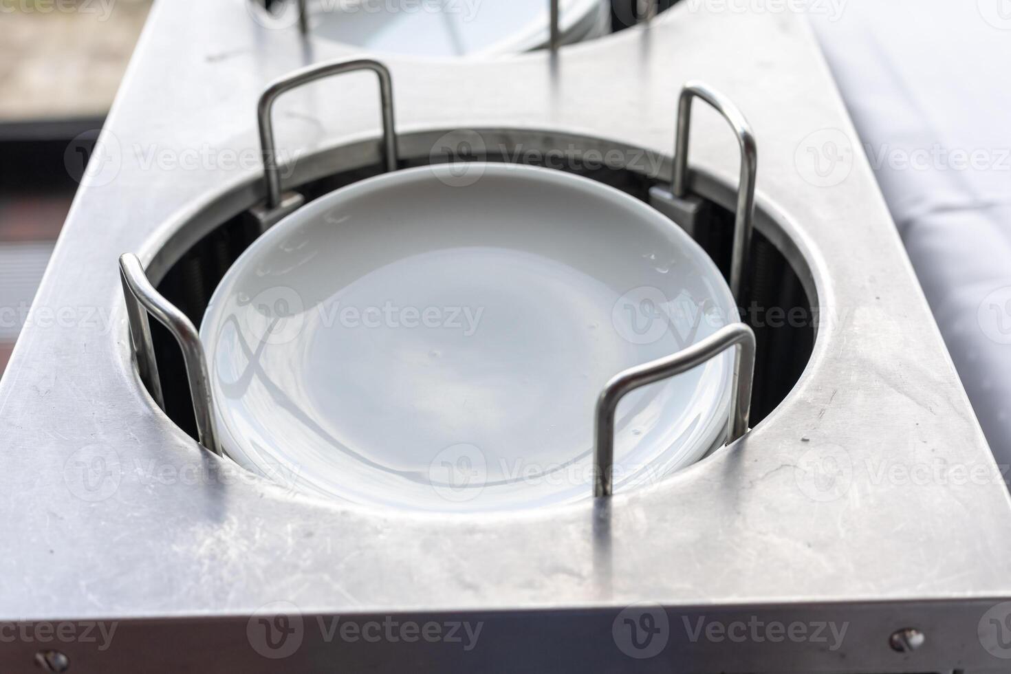 Plates being heated in a stainless steel hot cabinet during a catering event at a sunny outdoor venue photo