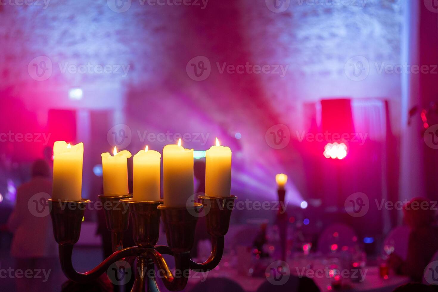 Warm candlelight illuminates a festive gathering with vibrant lights at a charming venue during an evening celebration photo