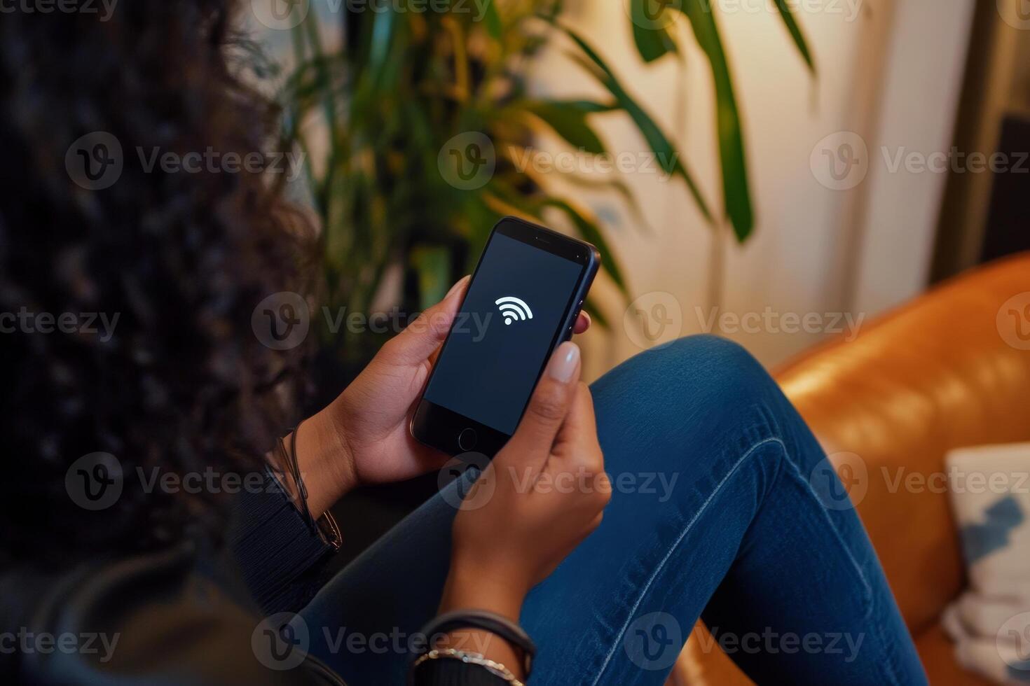 Using a smartphone to connect to Wi-Fi while relaxing on a couch in modern living room photo