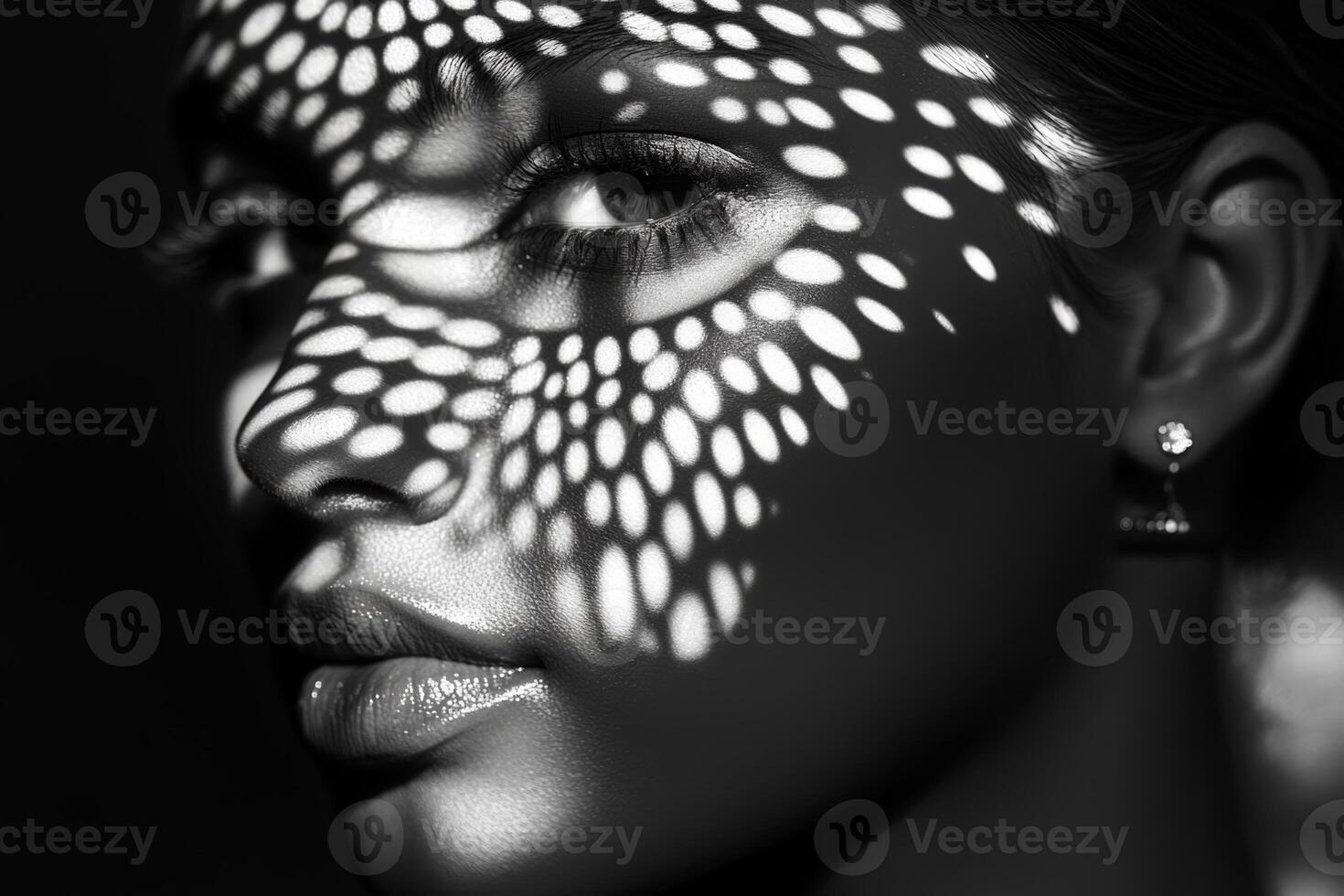 Model with intricate light pattern shadows on her face against a dark background creating a striking visual effect photo