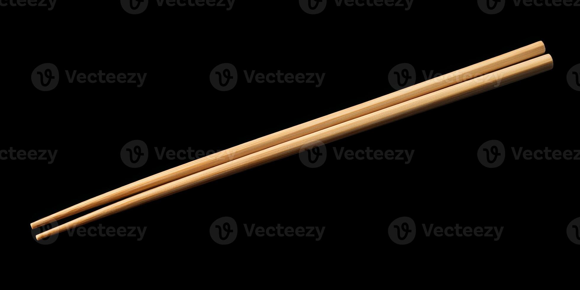 Simple wooden chopsticks resting on a dark surface showcasing traditional Asian dining utensils photo