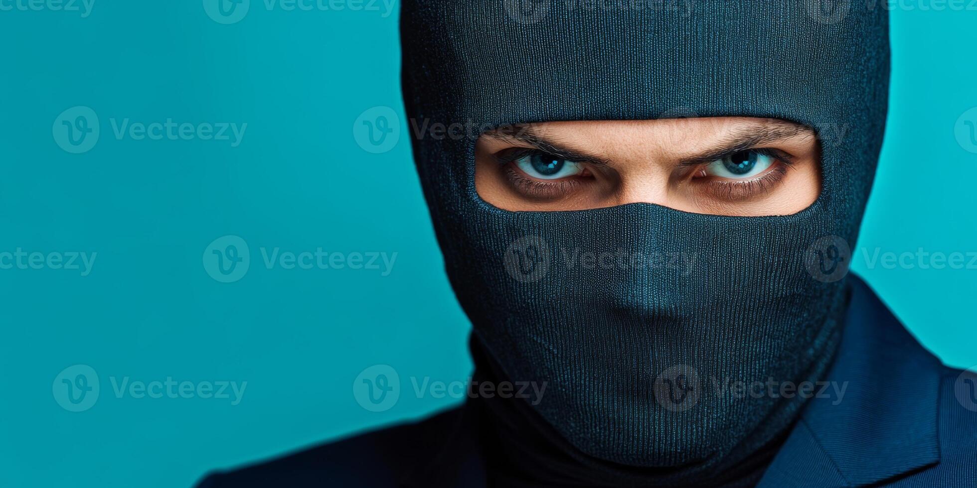 Mysterious figure in a black mask with piercing blue eyes against a vibrant turquoise background photo