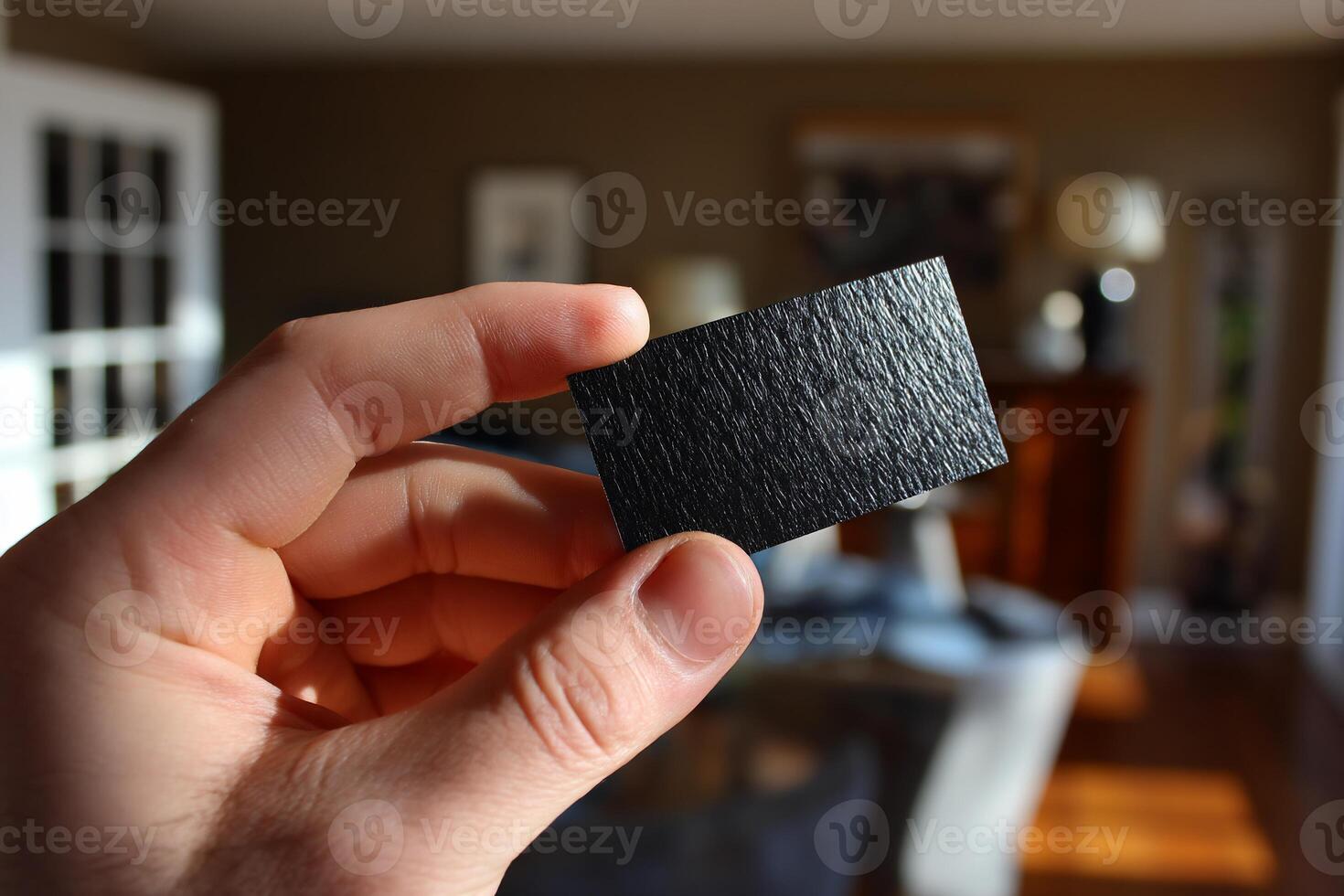 A person holding a small black square in their hand photo