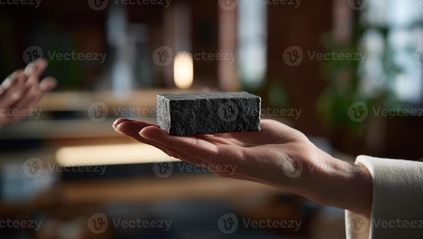 Dark gray stone block held in hand photo