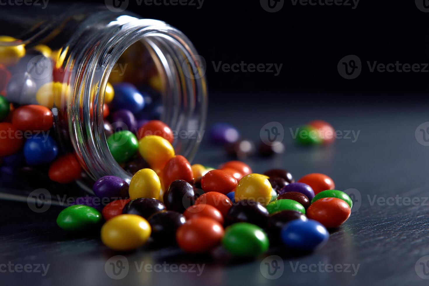 Colorful chocolate candies spilled from a glass jar photo
