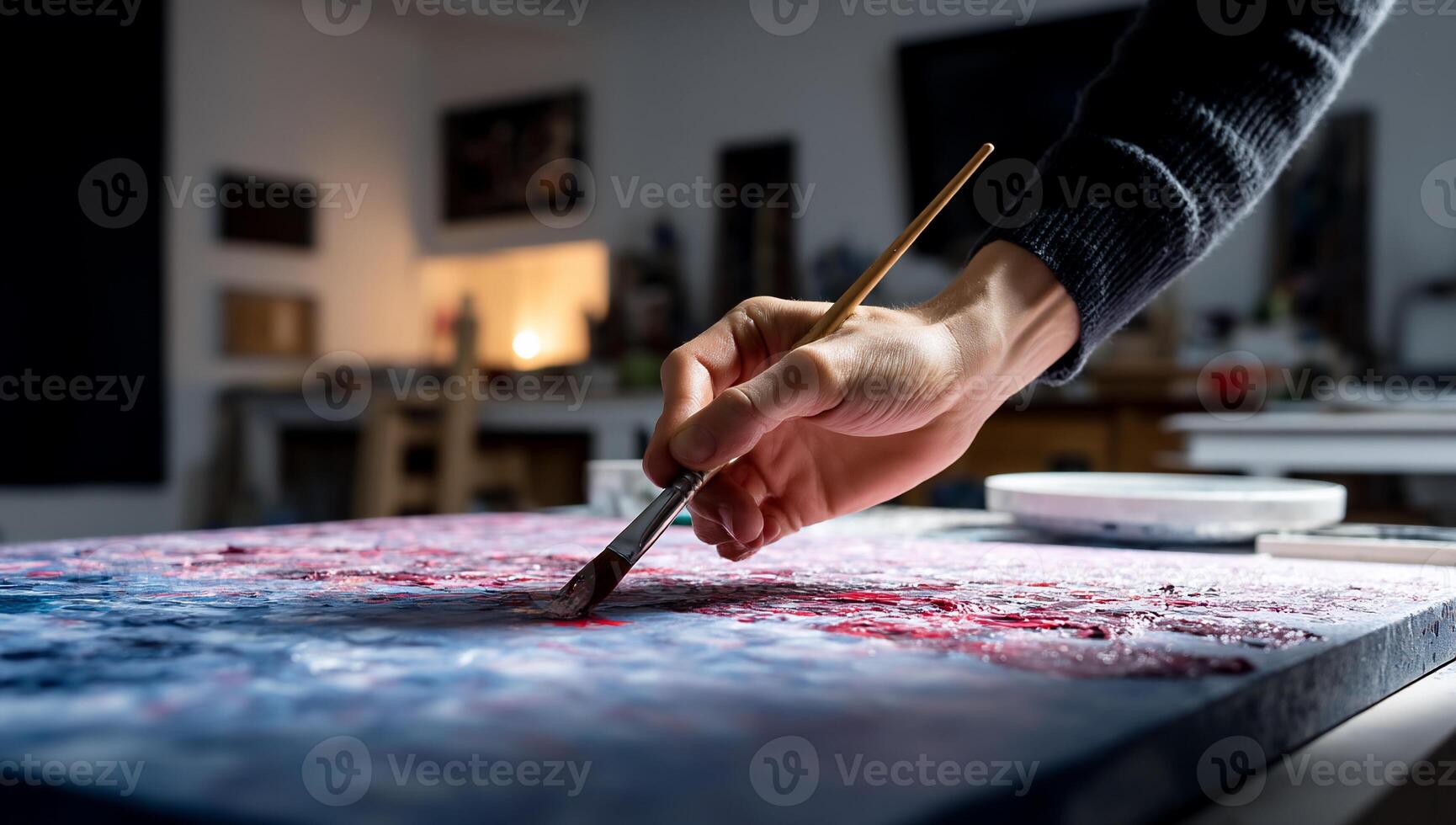 A person is painting on a canvas with a brush photo