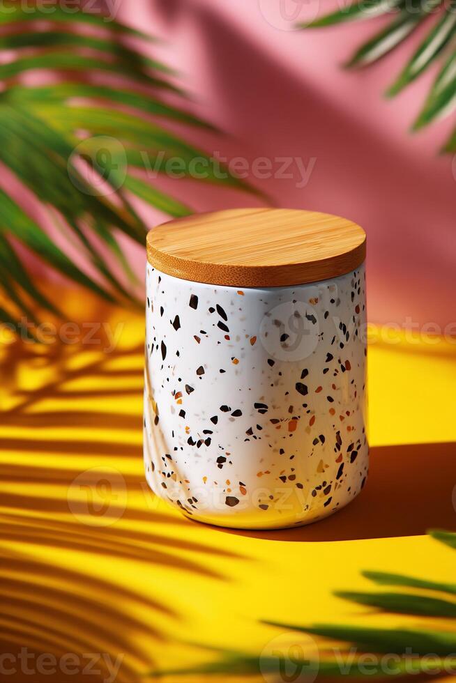Stylish ceramic storage jar with bamboo lid, set against a backdrop of vibrant colors and tropical foliage photo
