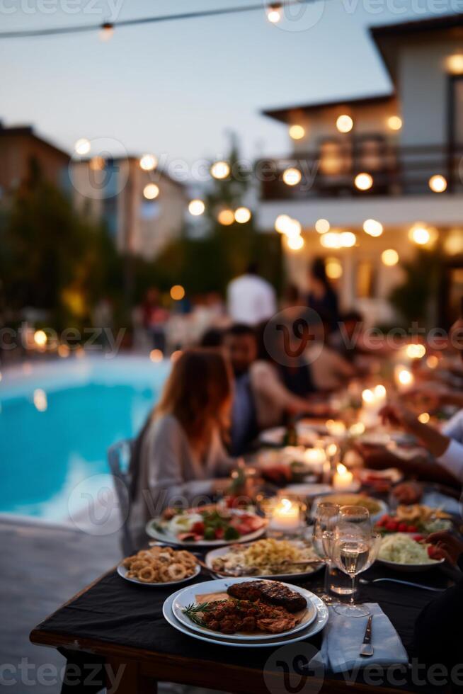 Outdoor dinner party by pool at dusk photo
