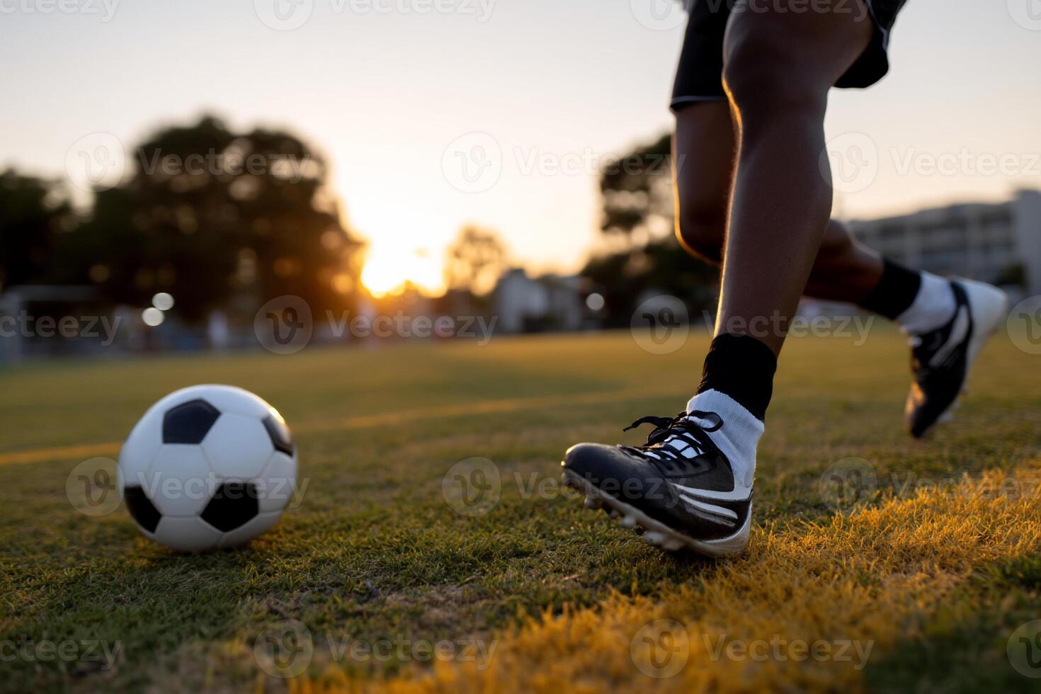Close-up of a soccer player in action at sunset photo