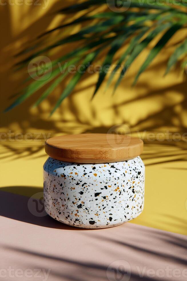 A white jar with a wooden lid sitting on a yellow background photo