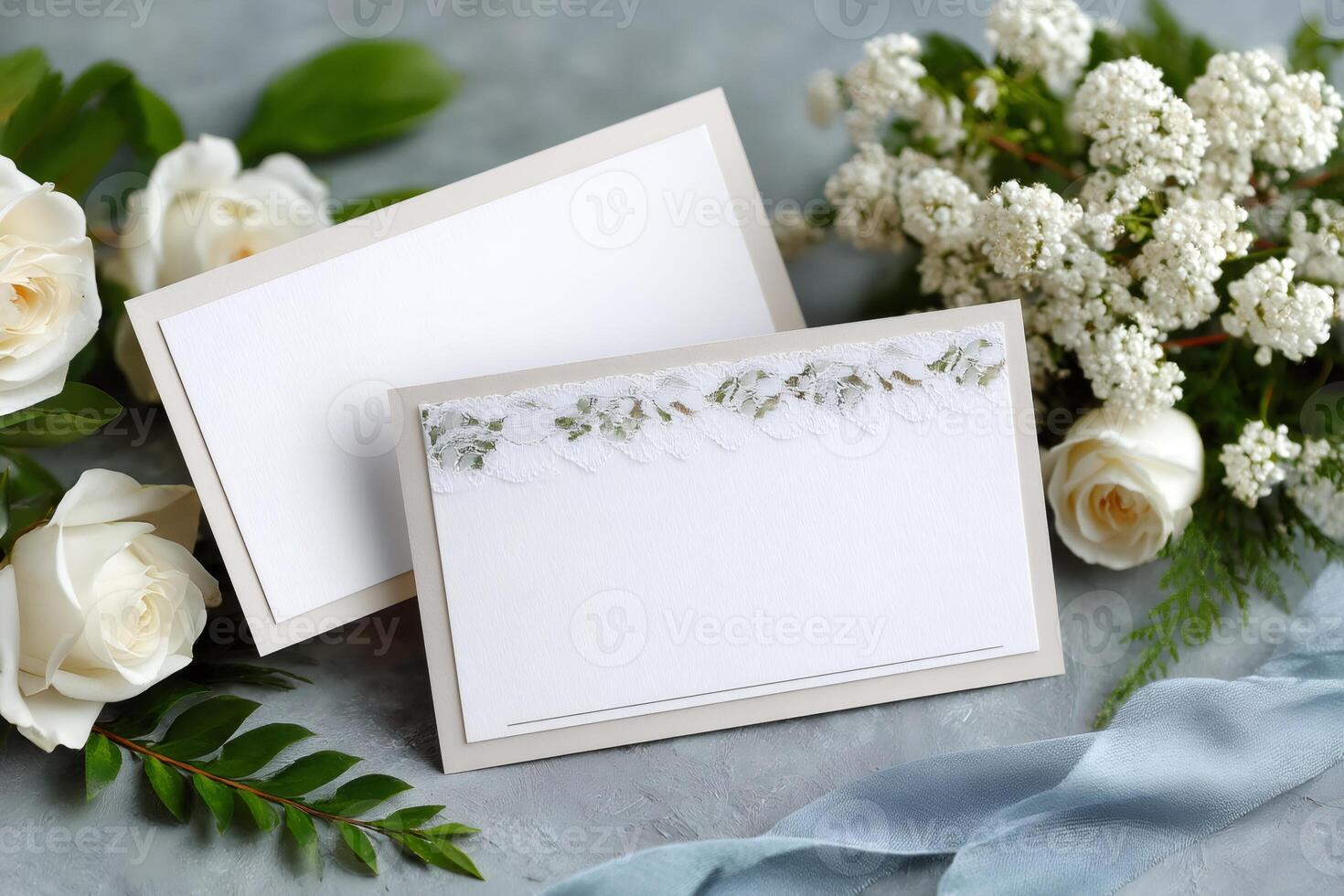 Elegant wedding stationery mockup with lace, white roses and gypsophila flowers on gray background photo