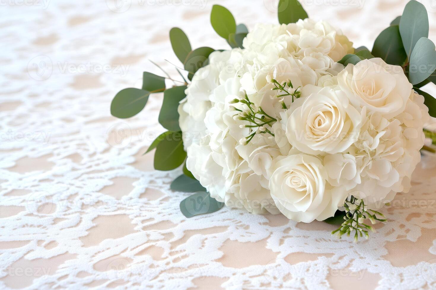 White roses and hydrangeas composing a beautiful wedding bouquet lying on lace tablecloth photo