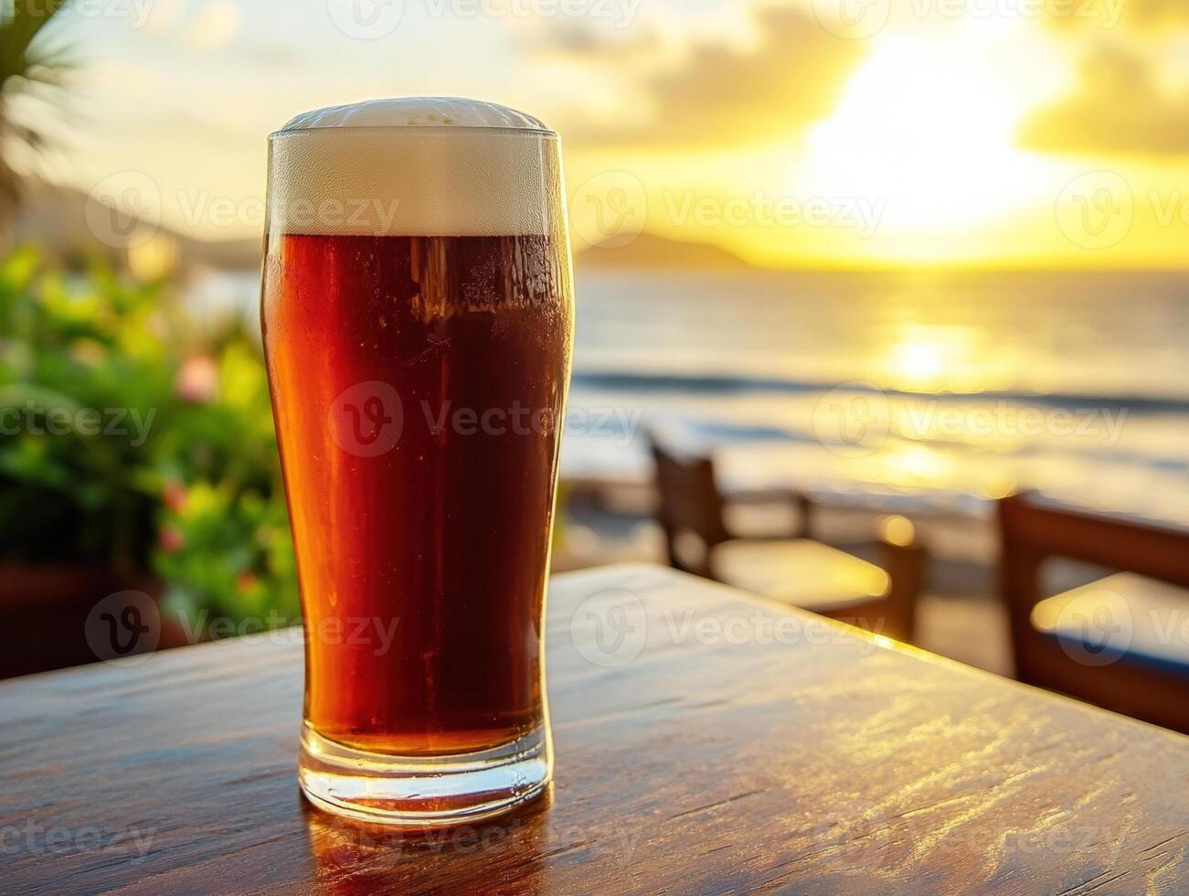 Sunset drinks by the beach with a refreshing amber beer photo