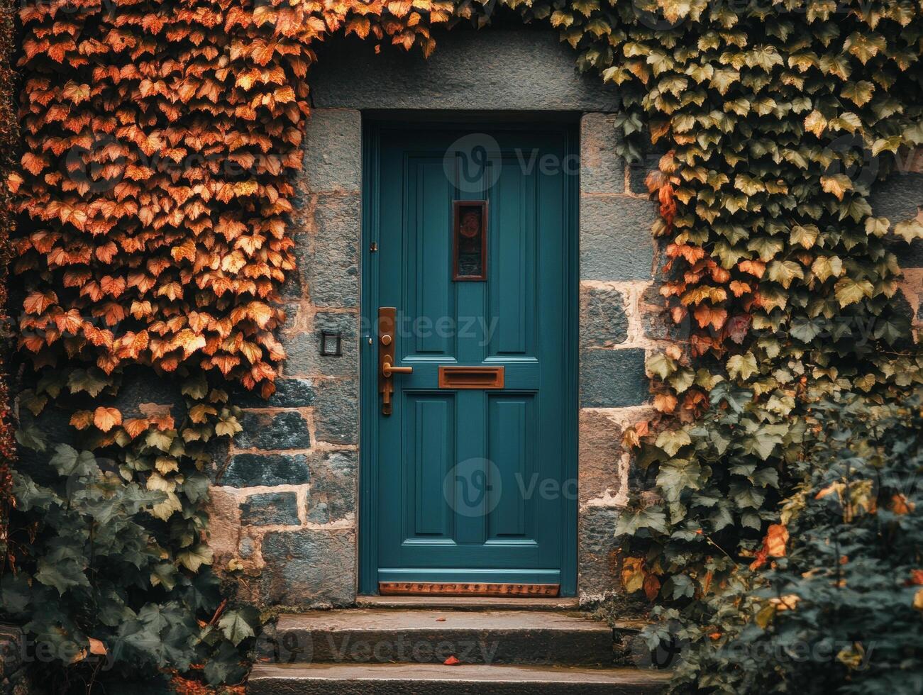 Beautiful teal door surrounded by autumn leaves in a quaint setting photo