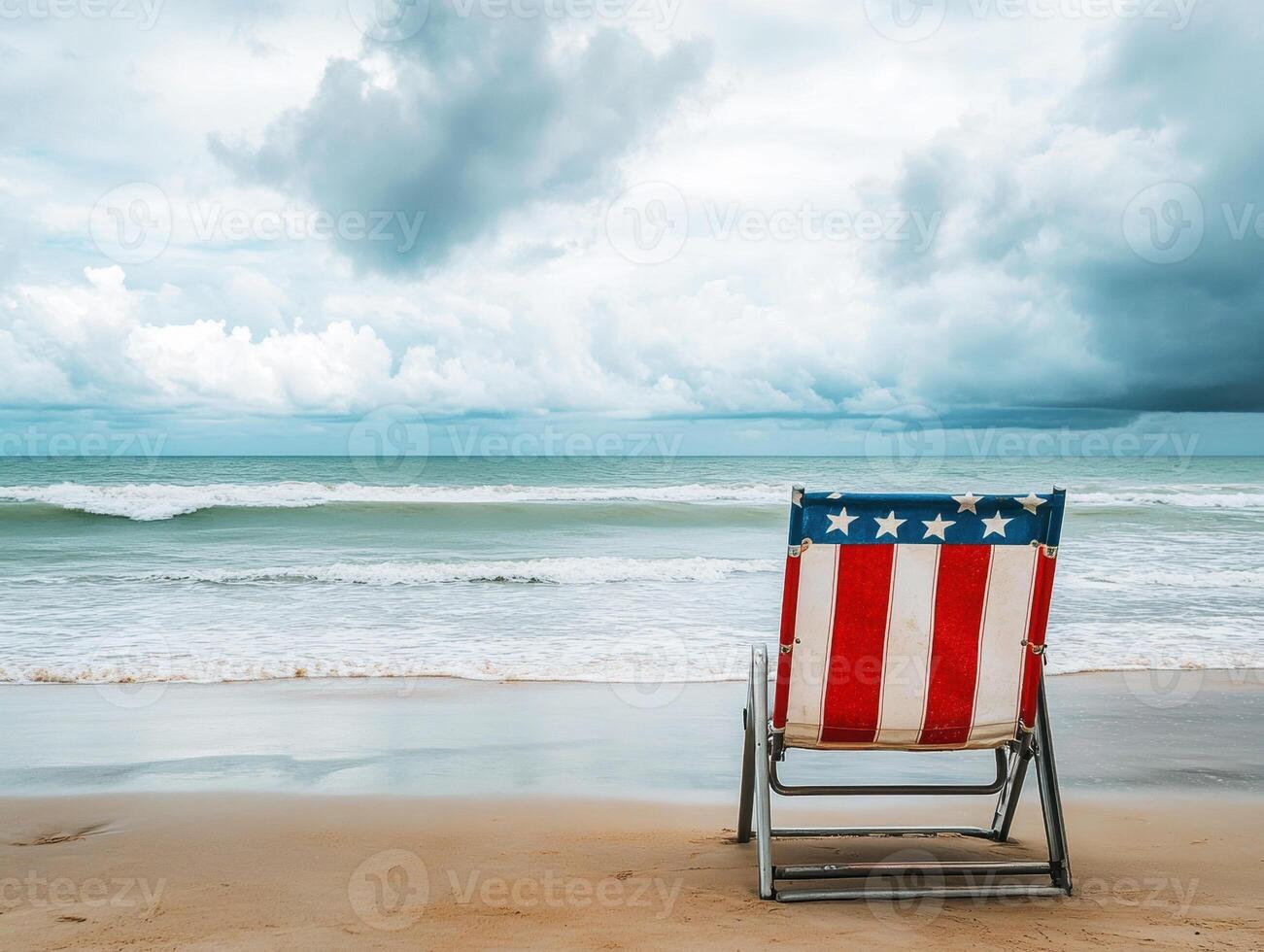 Beach chair facing ocean with cloudy sky in the background photo