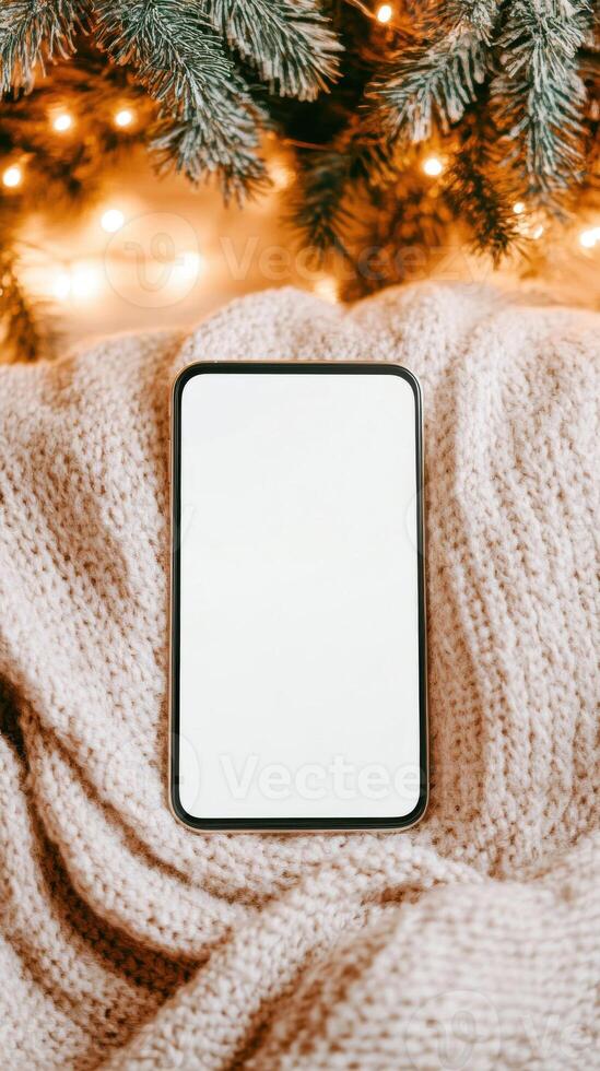 Smartphone mockup with Christmas lights and cozy blanket photo
