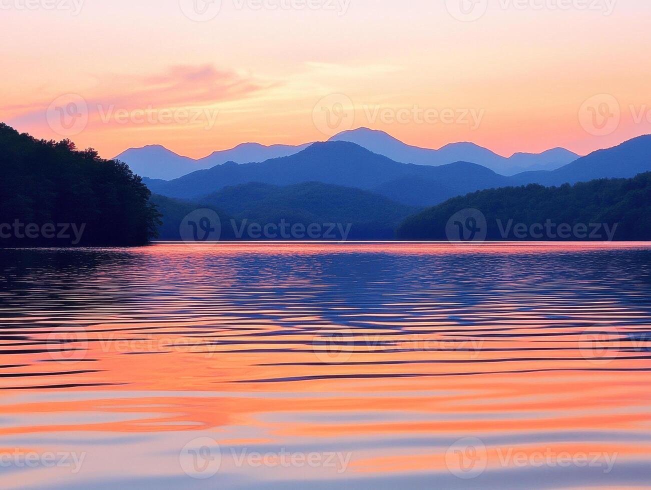 Sunset over tranquil lake with mountain backdrop in serene setting photo