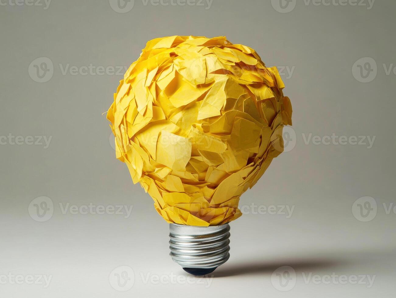 Creative light bulb made from yellow paper scraps in a studio setting photo