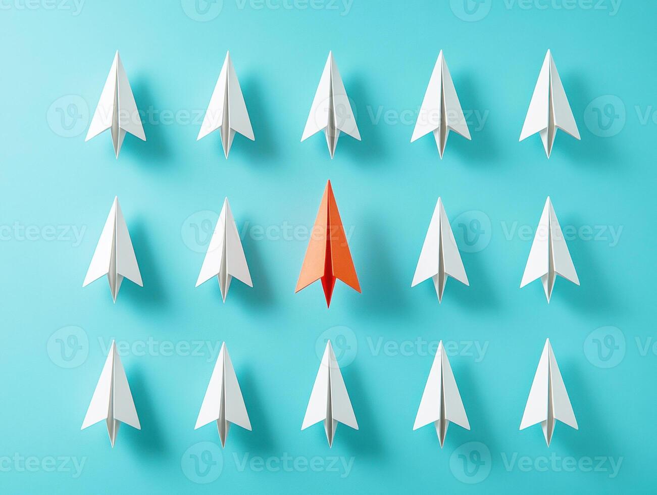 Red paper airplane stands out among white ones on blue photo
