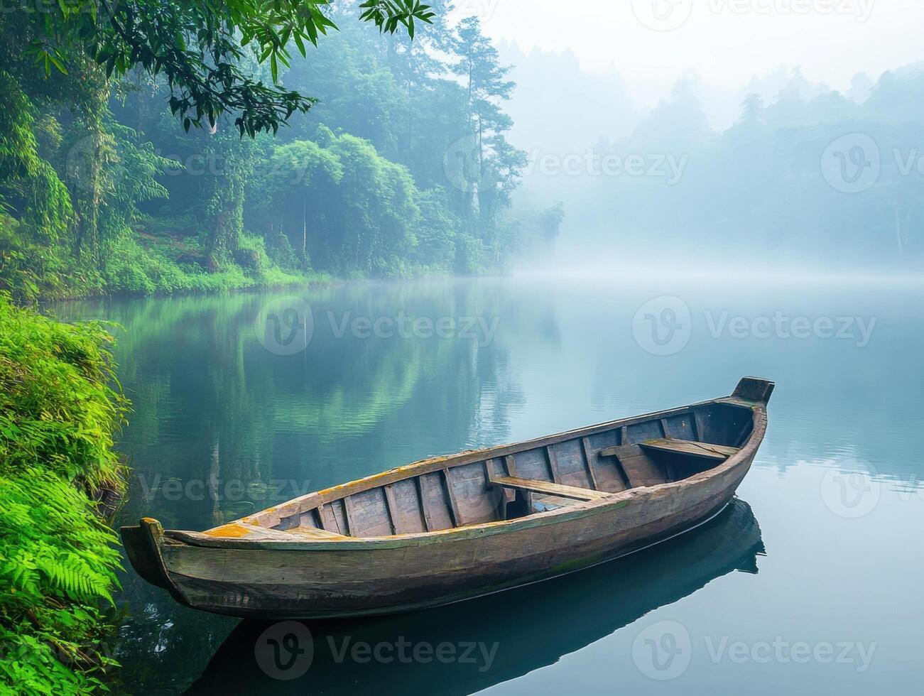 Calm boat resting on tranquil lake surrounded by misty forest in the early morning light photo