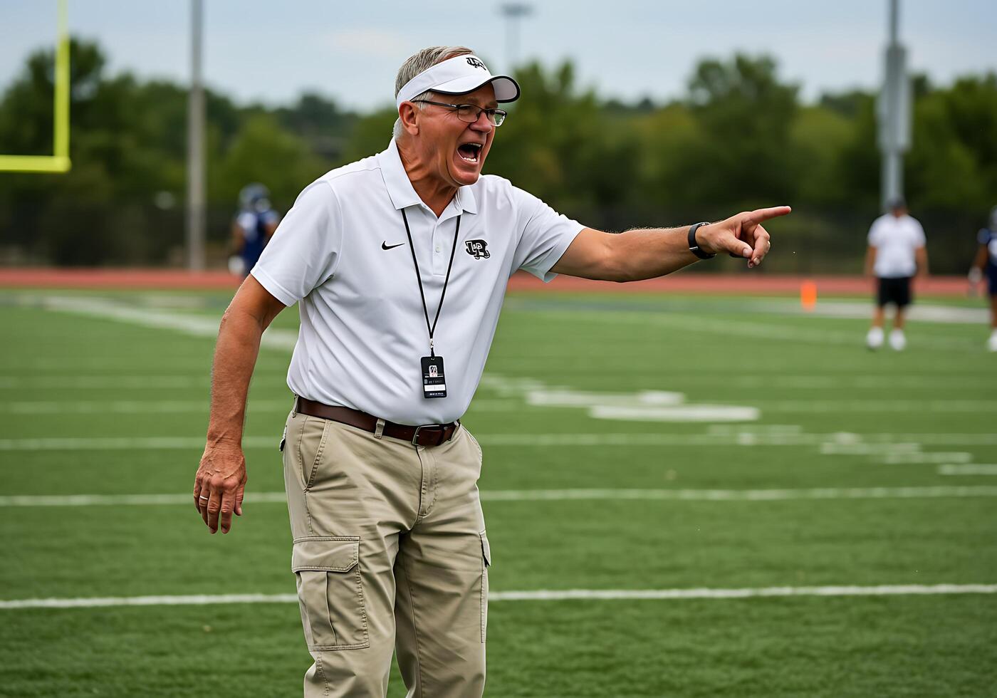 A coach on the field pointing to something photo