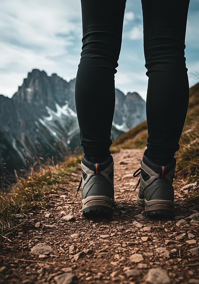 A person wearing hiking boots standing on a trail photo