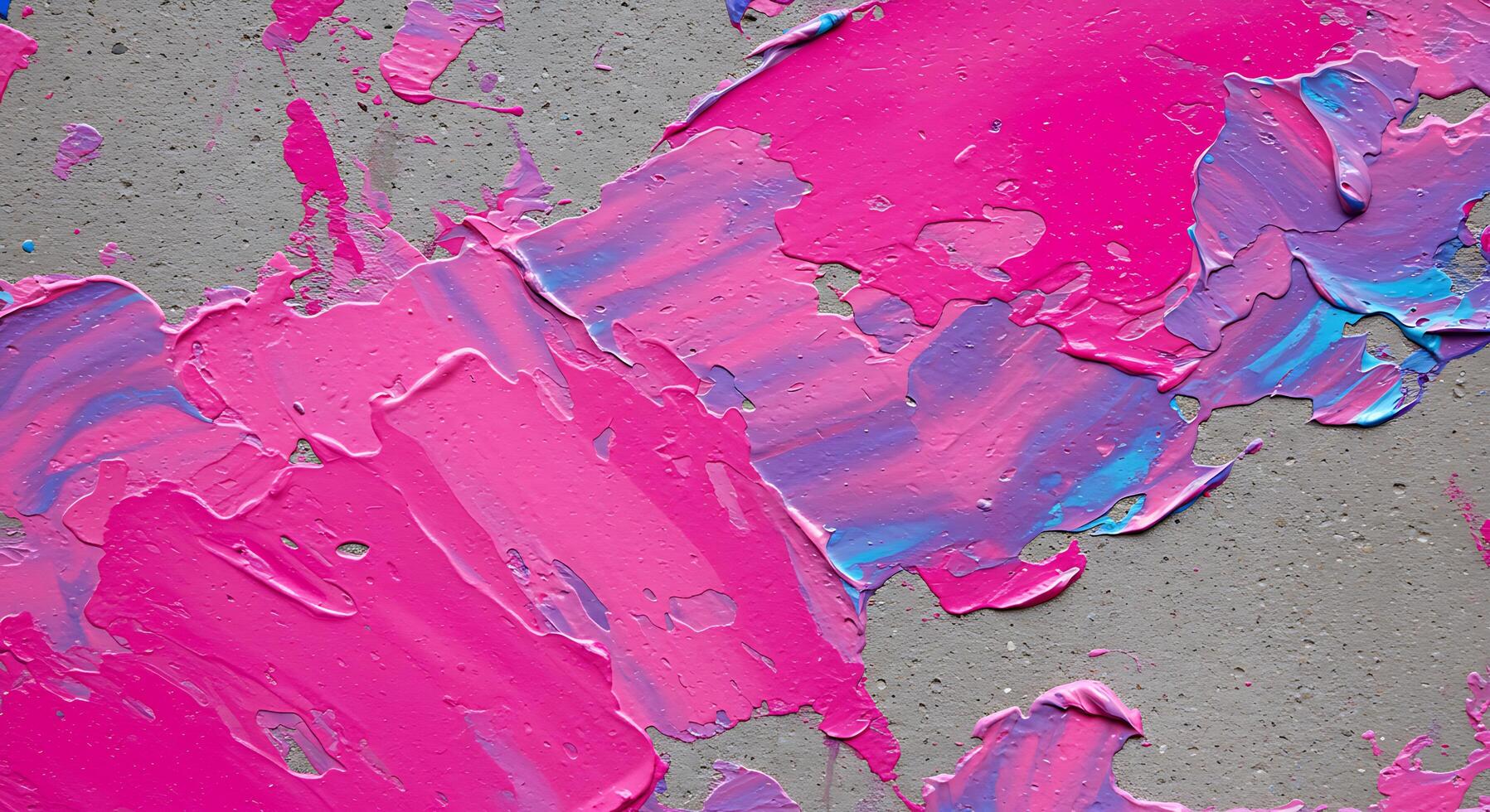 Pink and blue paint splatters on a concrete wall photo