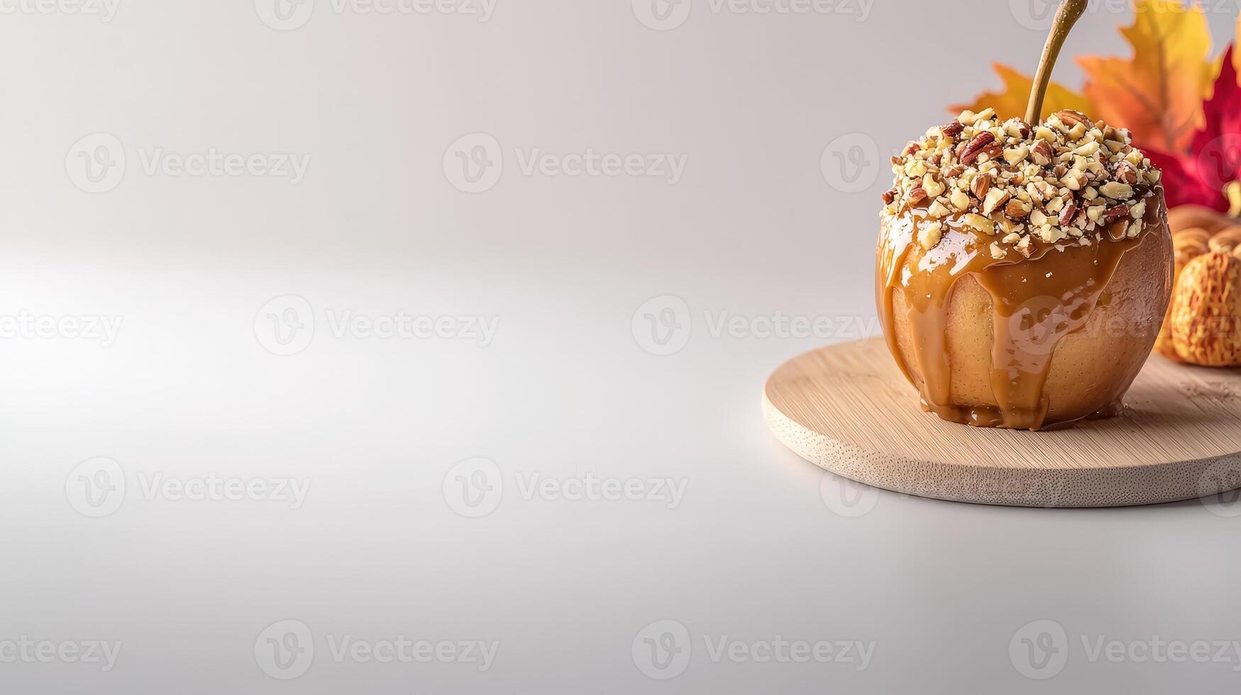 A delicious caramel drizzled with rich caramel sauce is topped with crunchy pecans and sits on a wooden board next to autumn leaves and pastries. photo