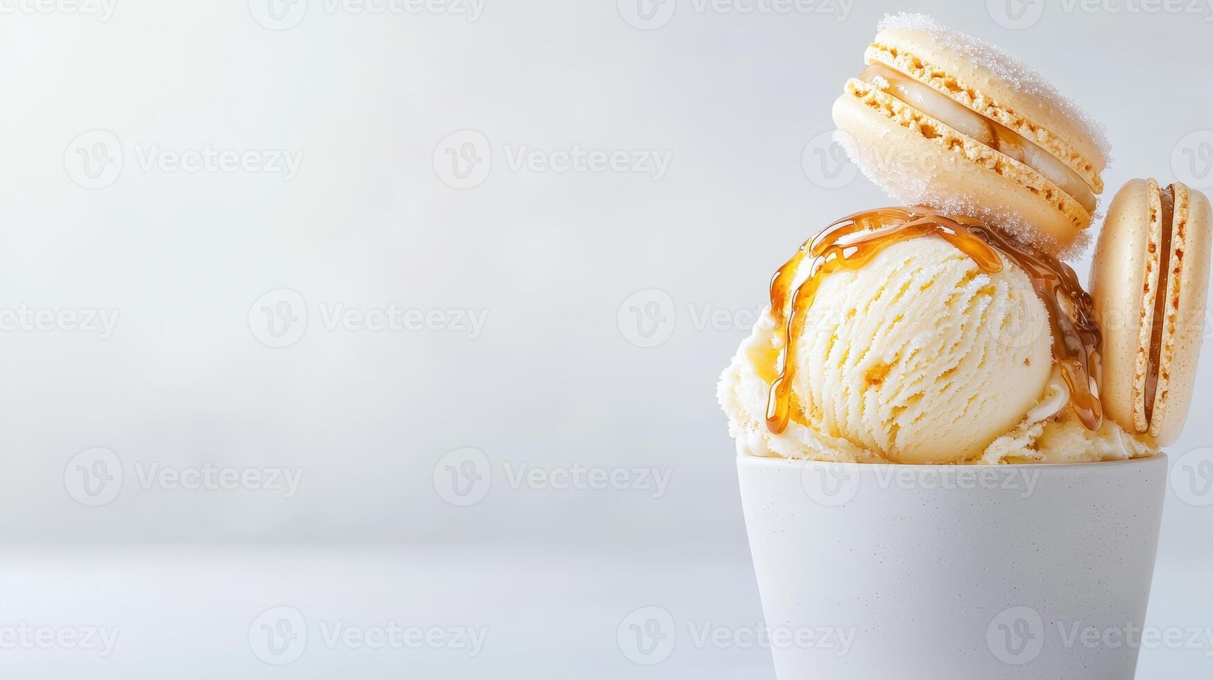 Creamy vanilla ice cream in a small white bowl topped with caramel sauce and delicate beige macarons creates a delightful dessert image perfect for culinary blogs and food photo
