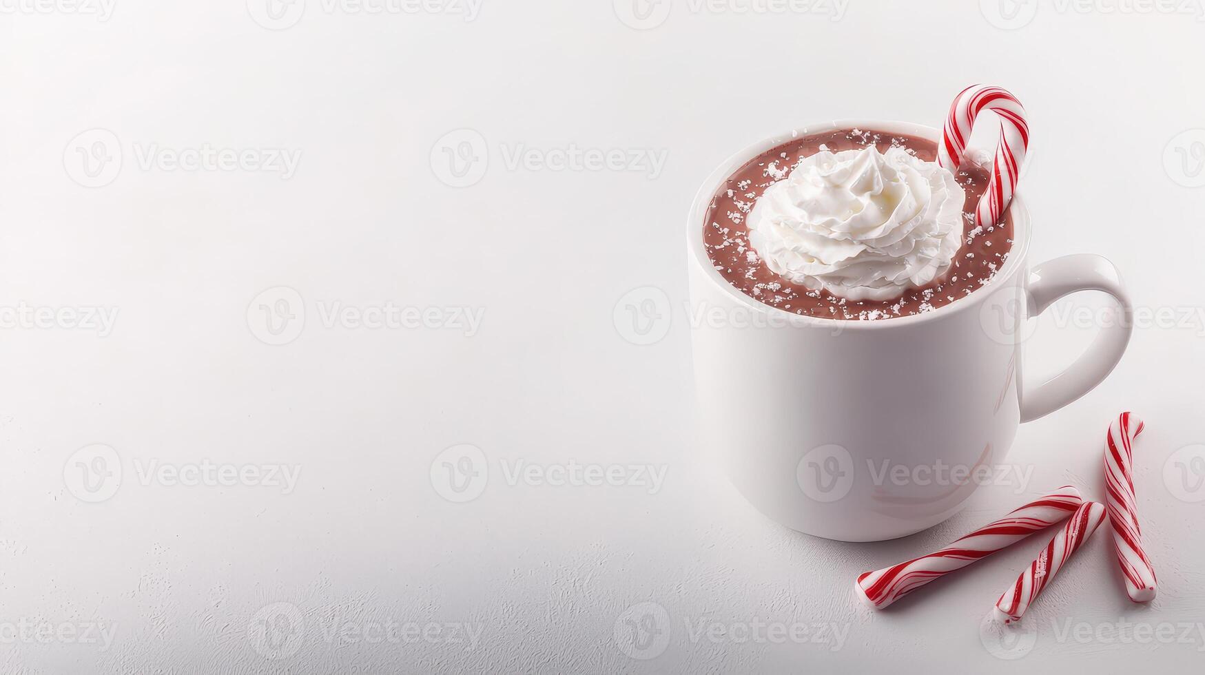A delicious cup of hot chocolate topped with whipped cream and a candy cane sits on a white background perfect for winter holiday themed designs and advertisements. photo