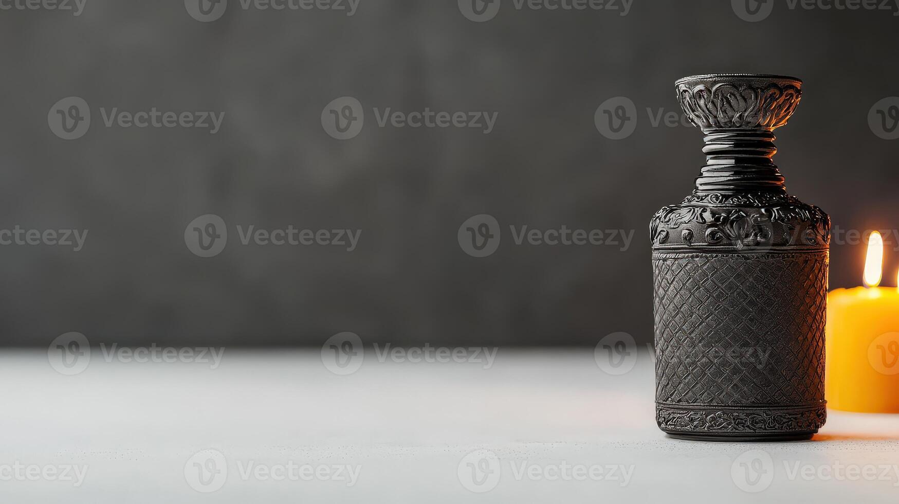 A candle and a bottle of perfume on a table photo