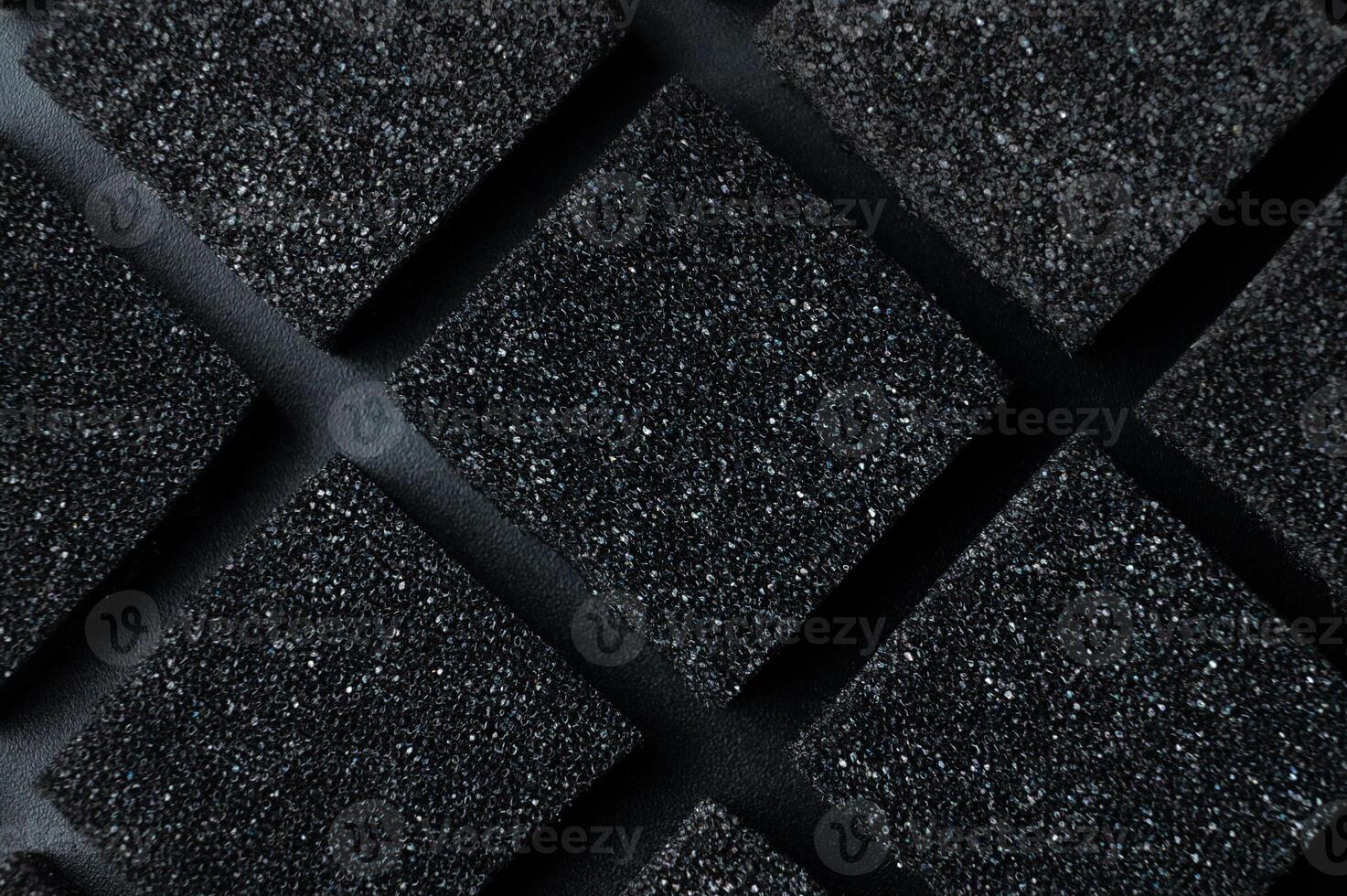 Black Cubes of flexible foam sponges laid out in a pattern. Macro close-up in soft focus. Abstract cubic background photo