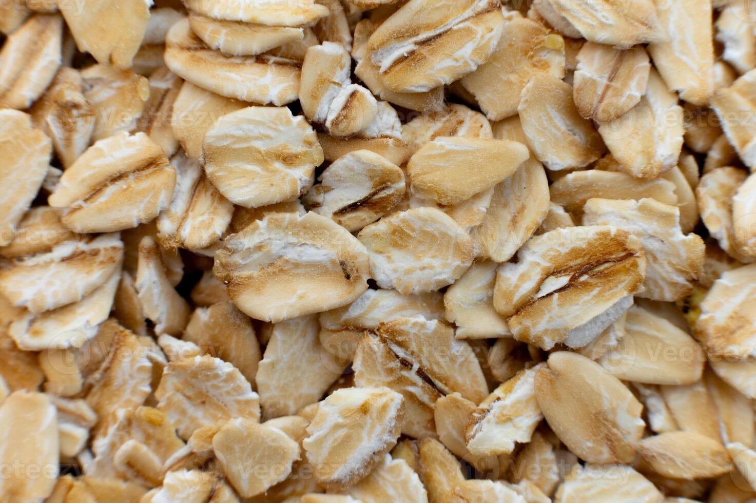 Close-up macro shot of raw oat flakes in shallow depth of field. Top view. photo