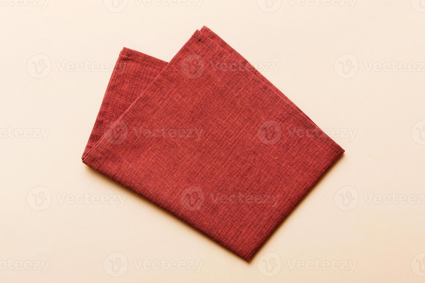 top view with red empty kitchen napkin isolated on table background. Folded cloth for mockup photo